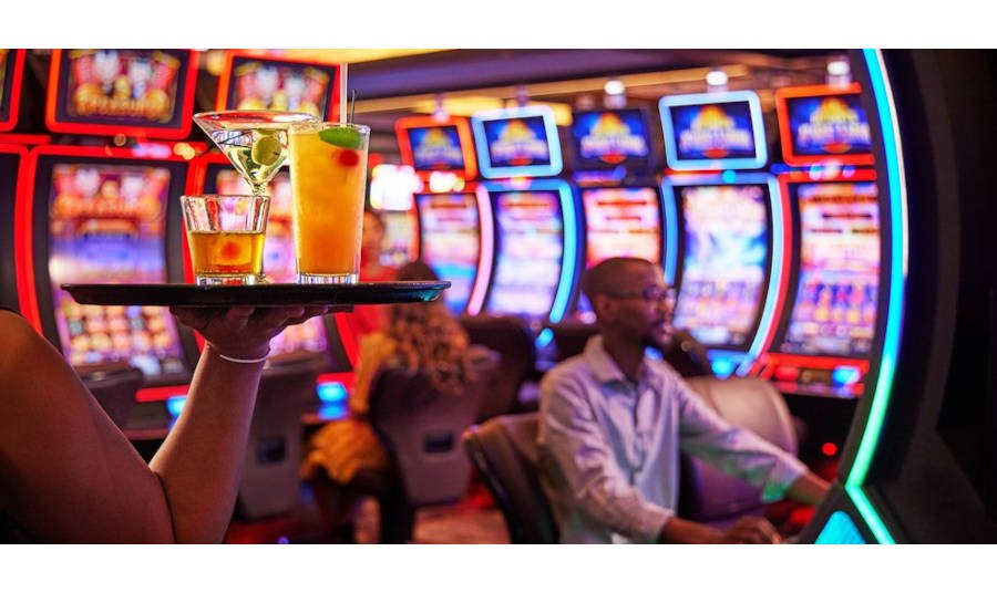 Waitress carry drinks past slot machines